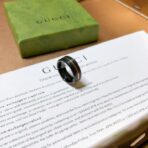 古驰（GUCCI）Icon 系列黑色合成刚玉配金色条纹宽版戒指 - Imagem 3