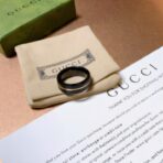 古驰（GUCCI）Icon 系列黑色合成刚玉配金色条纹宽版戒指 - Imagem 4